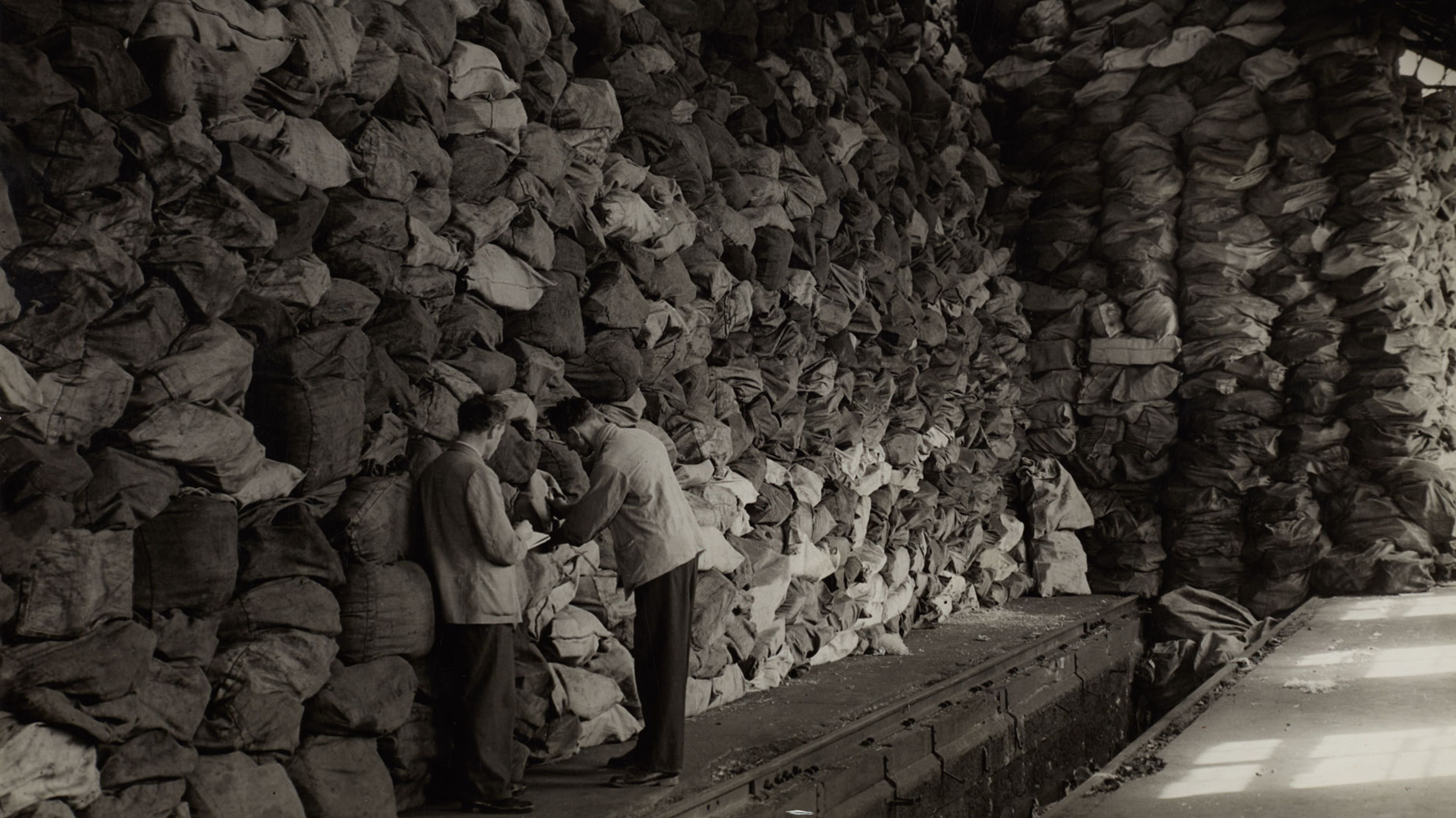 Du courrier de prisonniers de guerre à Bâle, des sacs postaux empilés pour la suite du transport, vers 1945. Source: robert Spreng (photographe) / Musée de la communication