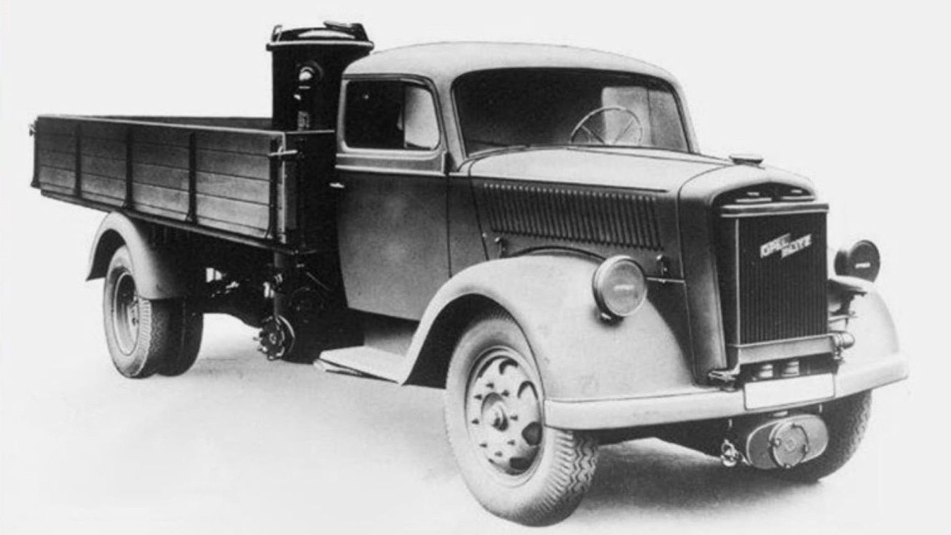 Photographie en noir et blanc d'un camion historique, tel qu'il était autrefois utilisé pour le transport de marchandises.