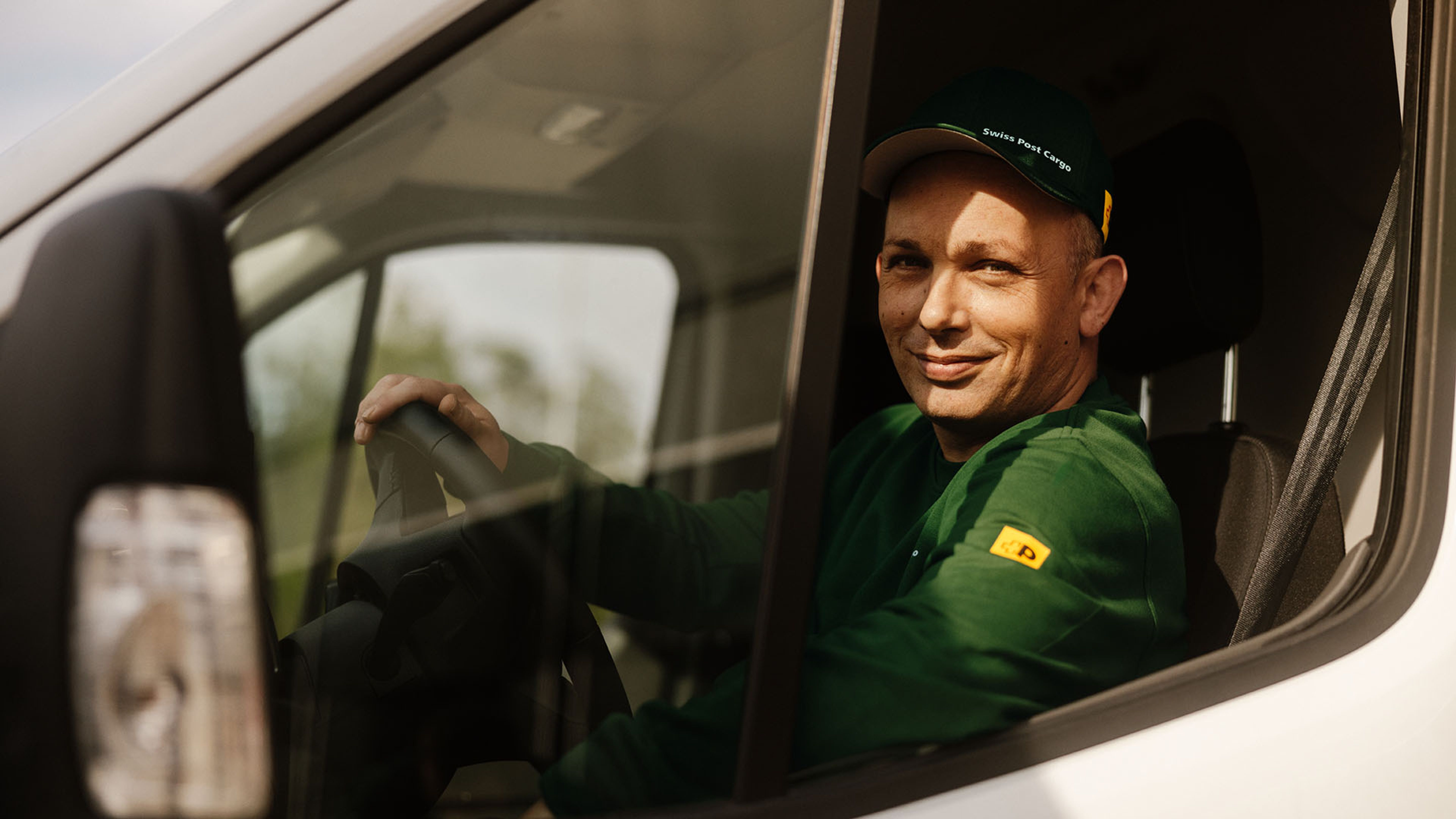 A Swiss Post Cargo driver steers a delivery vehicle with day courier shipments.