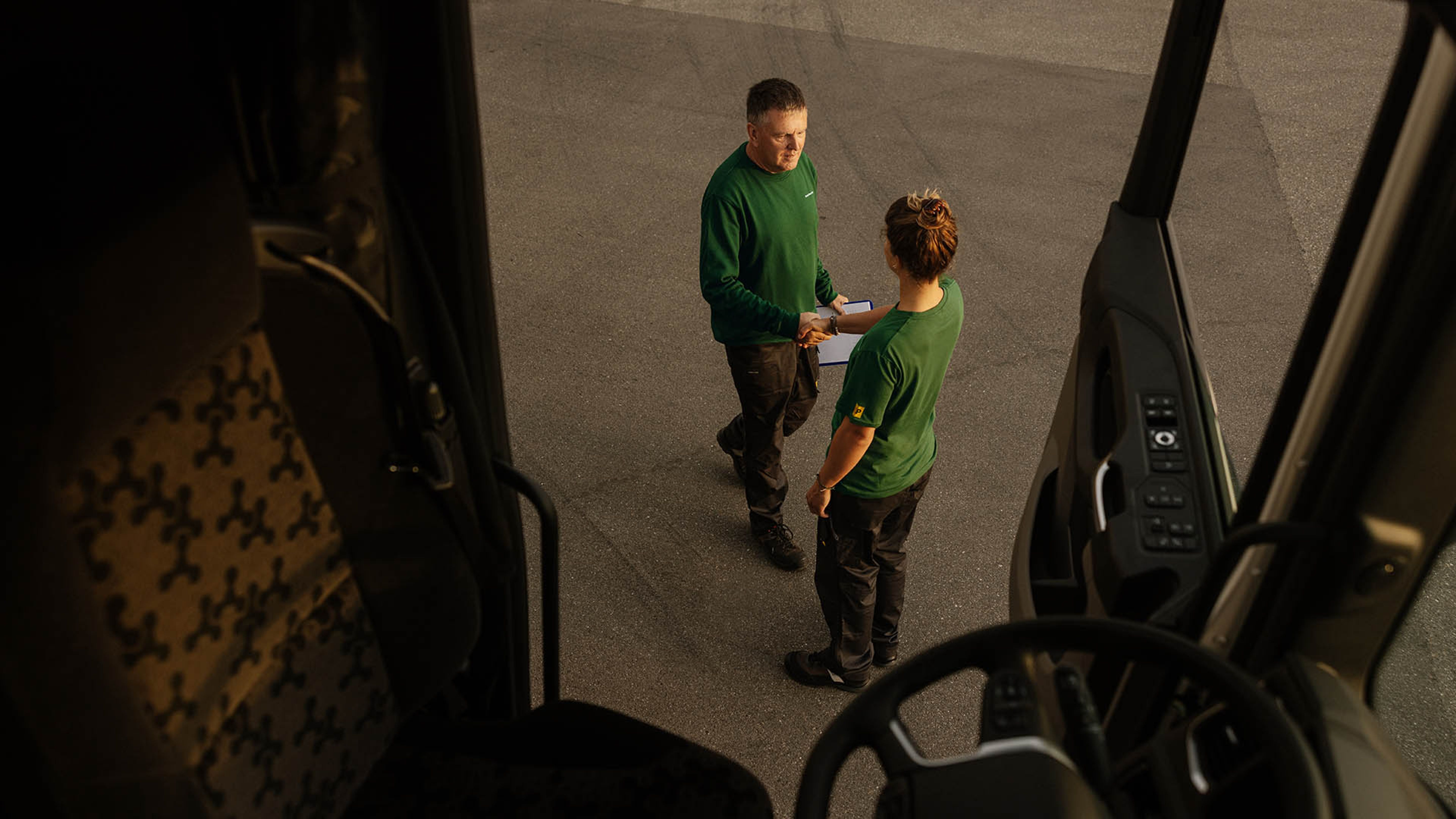 Two Swiss Post Cargo employees greet each other (photographed out of an open lorry).