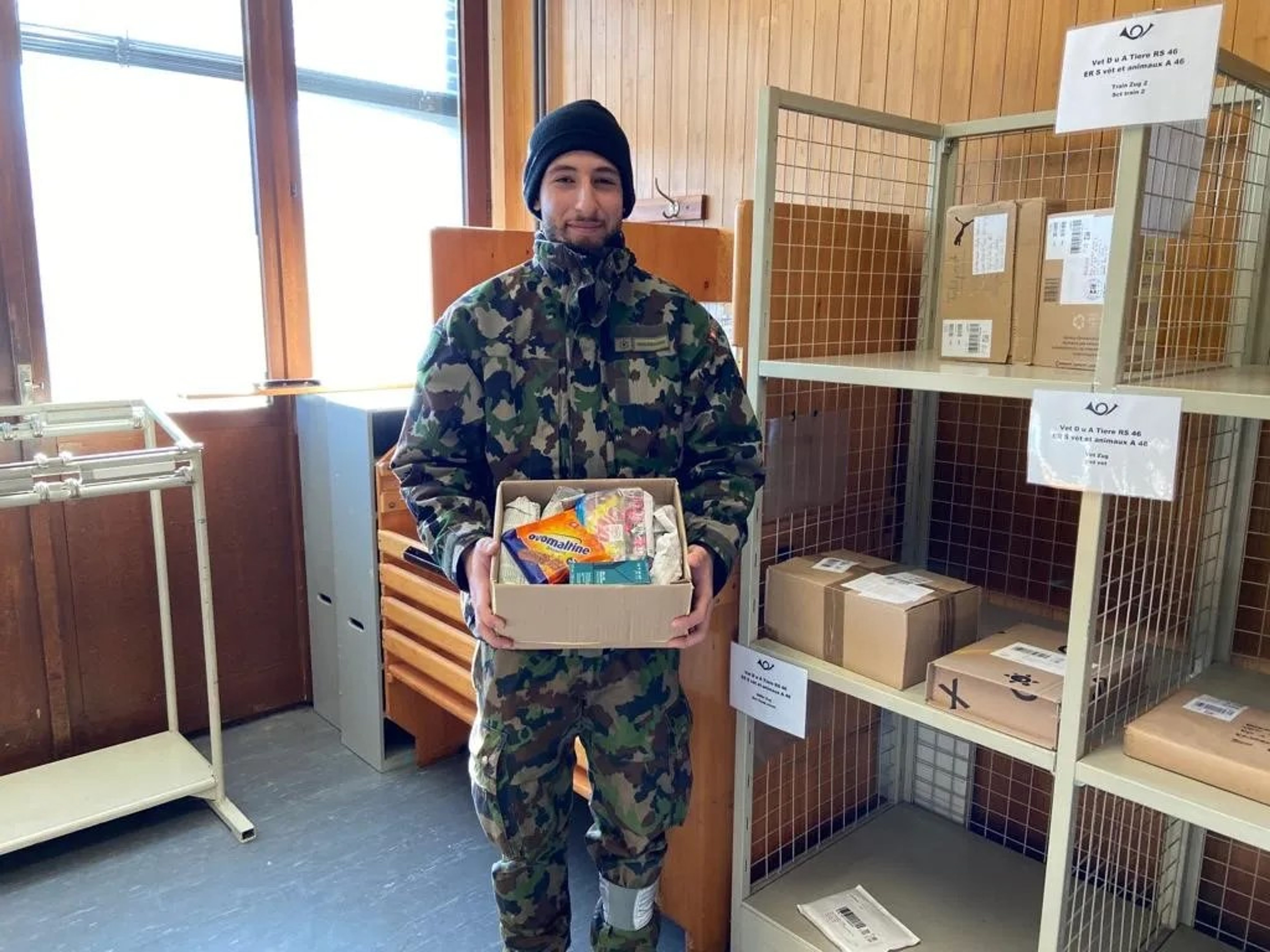 Rekrut Haidar freut sich sichtlich über sein Paket. | Bilder: Nathalie Dérobert/Schweizerische Post