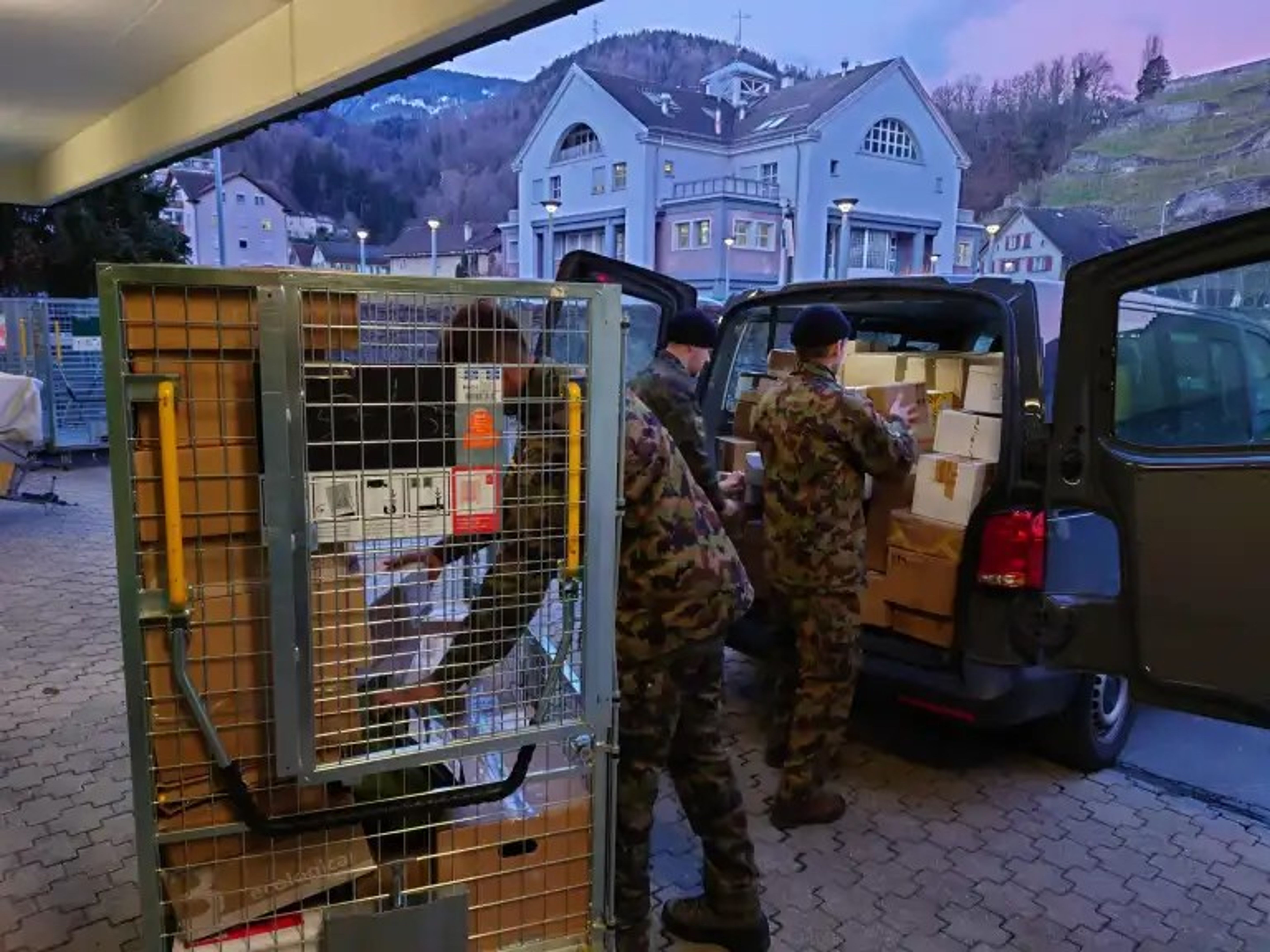 Die Soldaten der Feldpost beladen ein Fahrzeug mit Paketen. | Bilder: Schweizerische Post