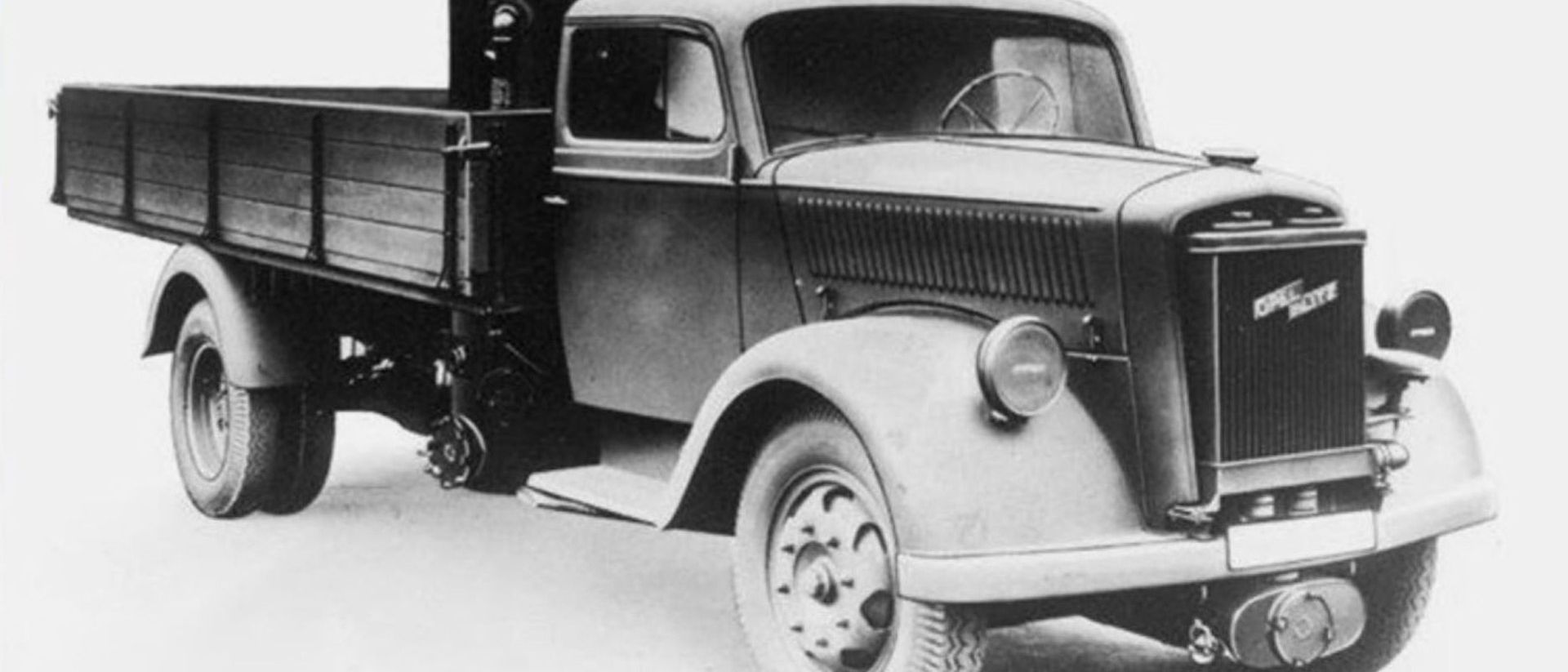 Schwarz-Weiß-Fotografie eines historischen Lastwagens, wie er einst für den Gütertransport genutzt wurde.