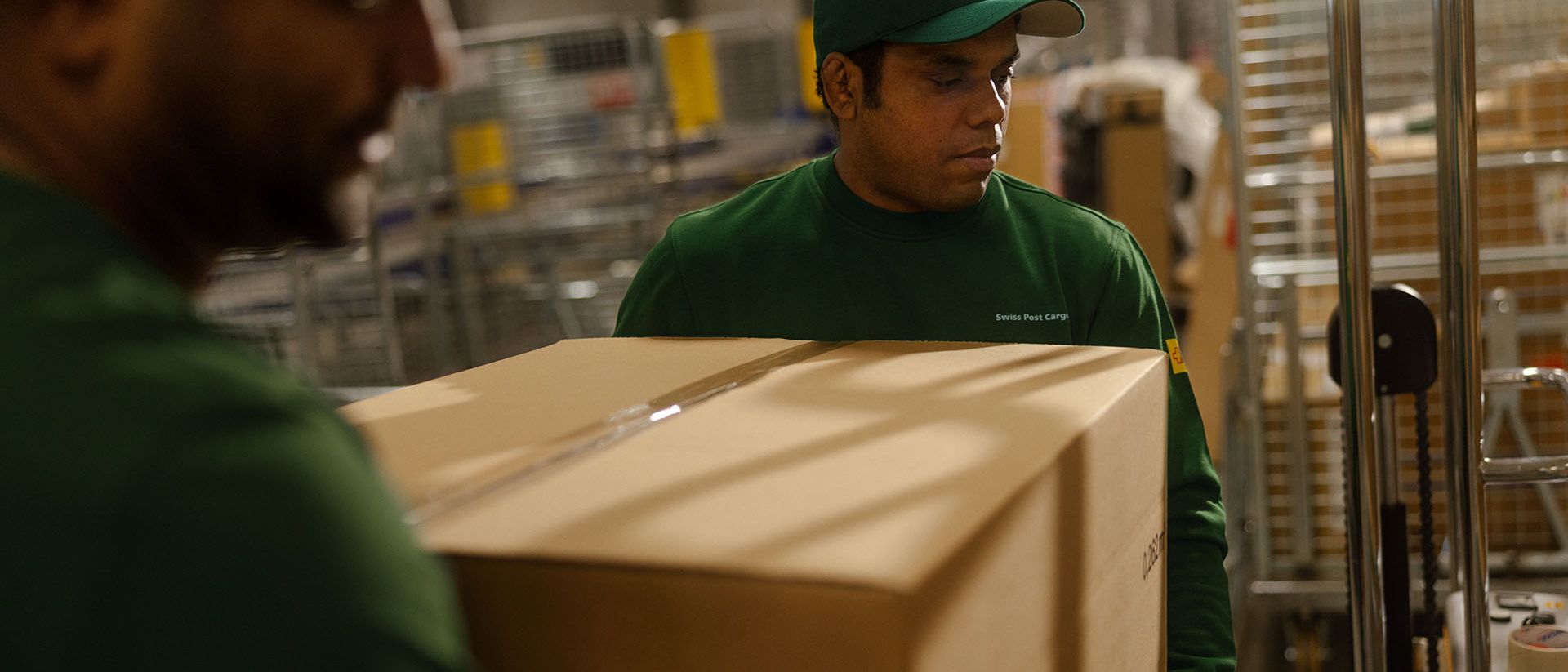 Two employees of Swiss Post Cargo deliver goods to a retail store overnight.