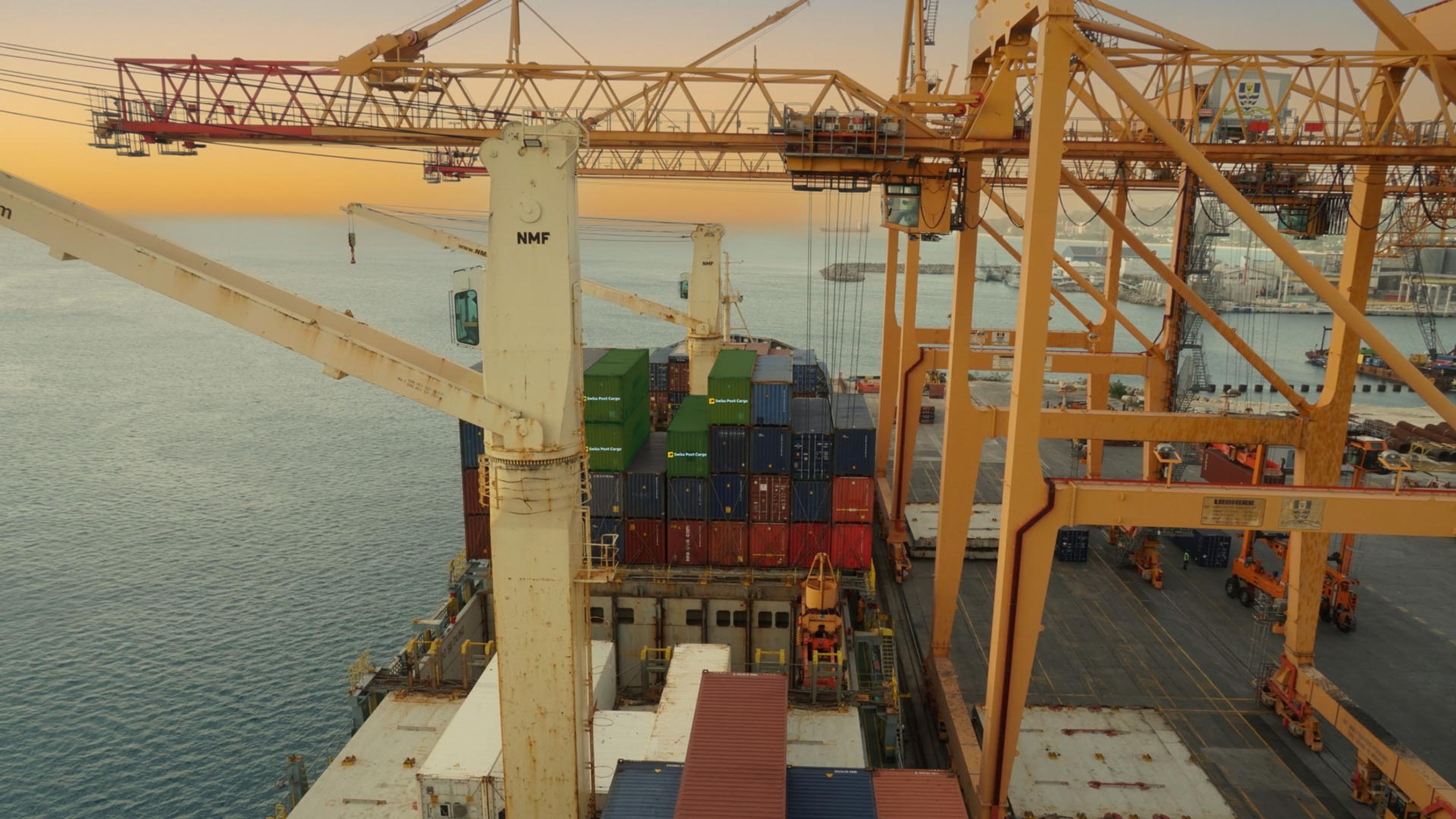 Conteneur Swiss Post Cargo sous une grue de fret dans le port