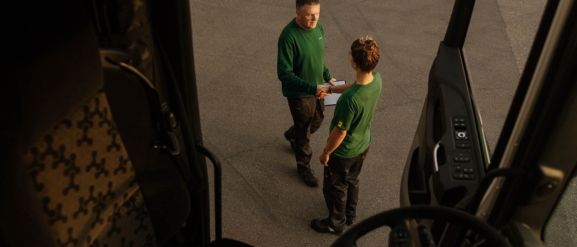 Due collaboratori di Swiss Post Cargo si danno il benvenuto (fotografati dall’autocarro aperto).