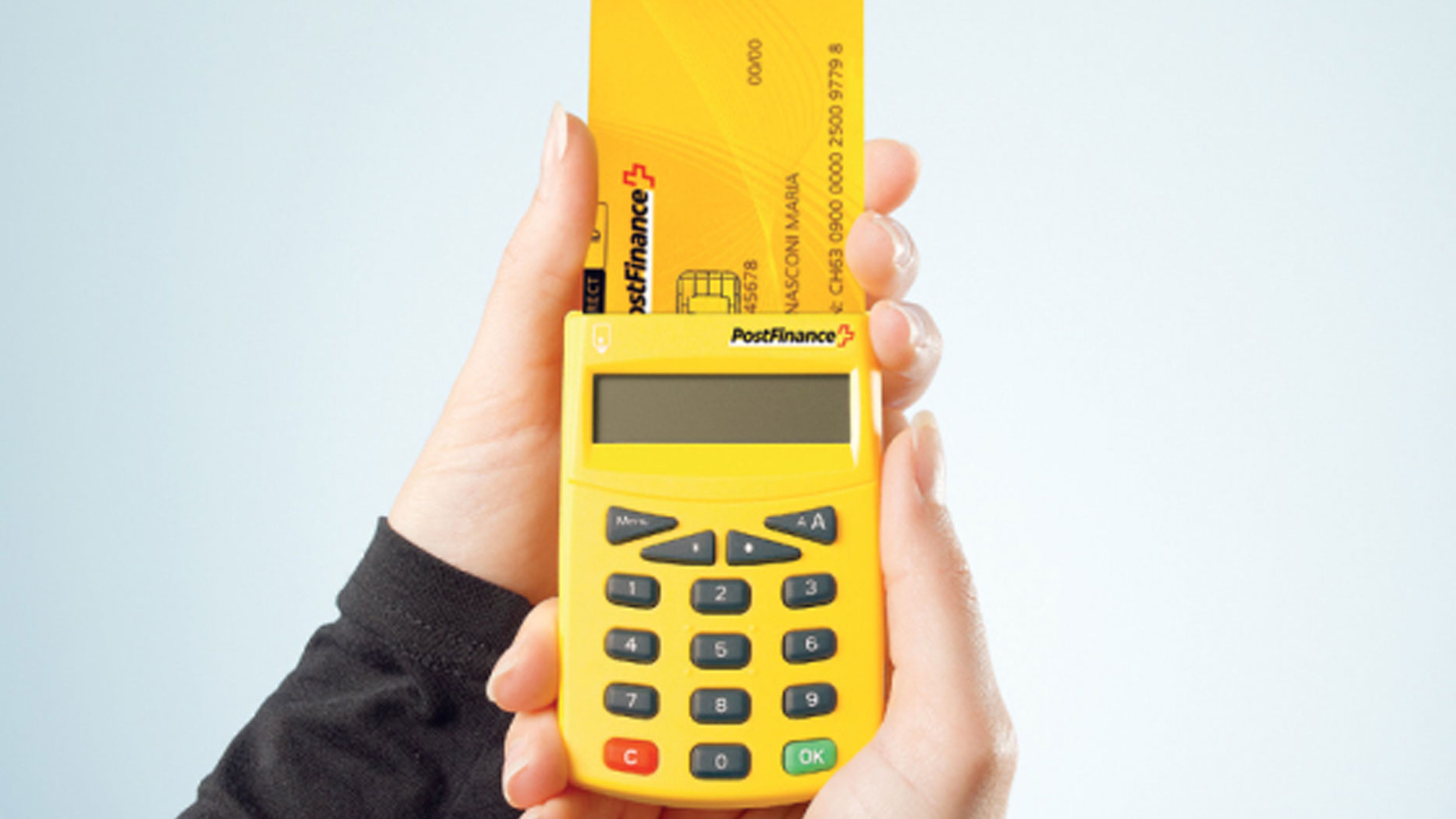 PostFinance-Karte wird in Kartenlesegerät gesteckt.