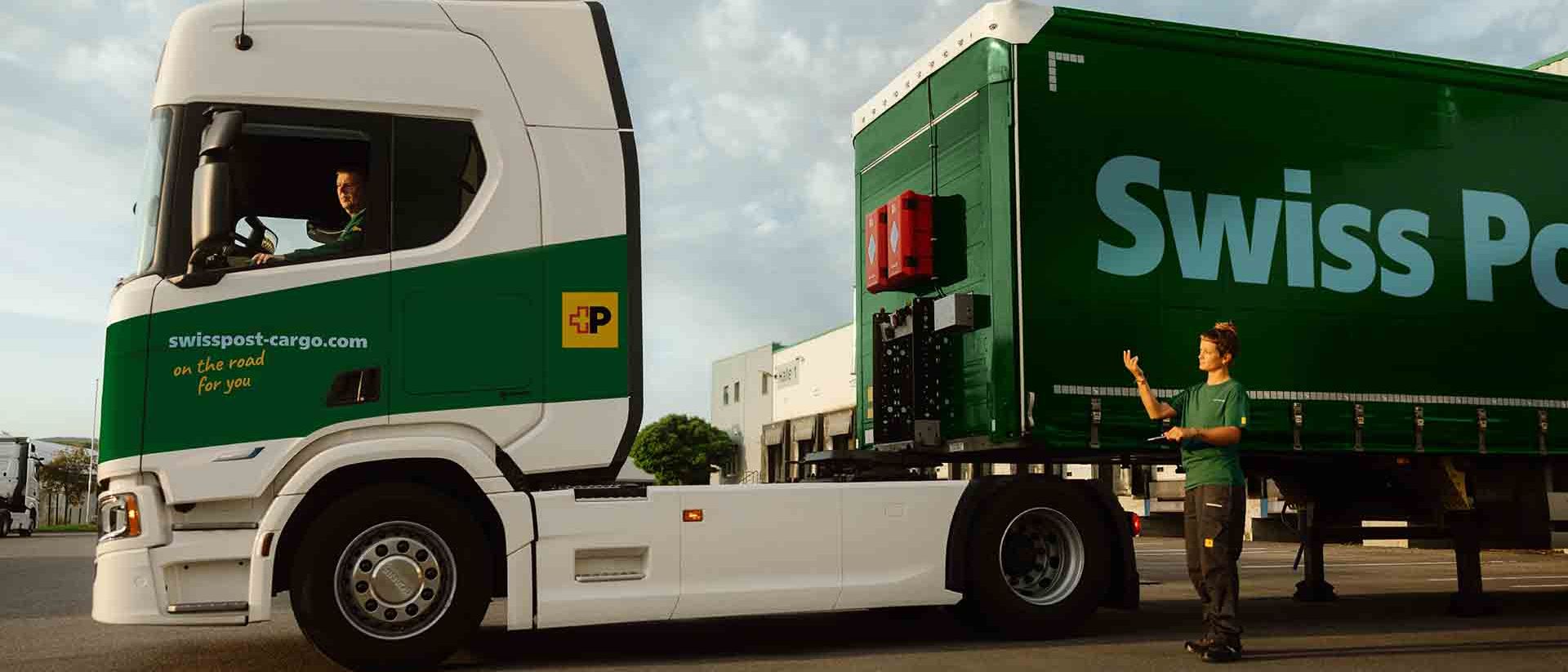 A Swiss Post Cargo truck driver couples a trailer with the help of a colleague.